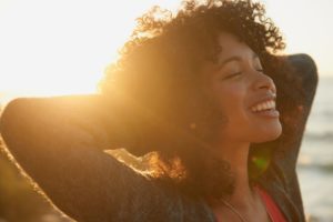 woman smiling in the sunset after wearing clear braces in Waco 